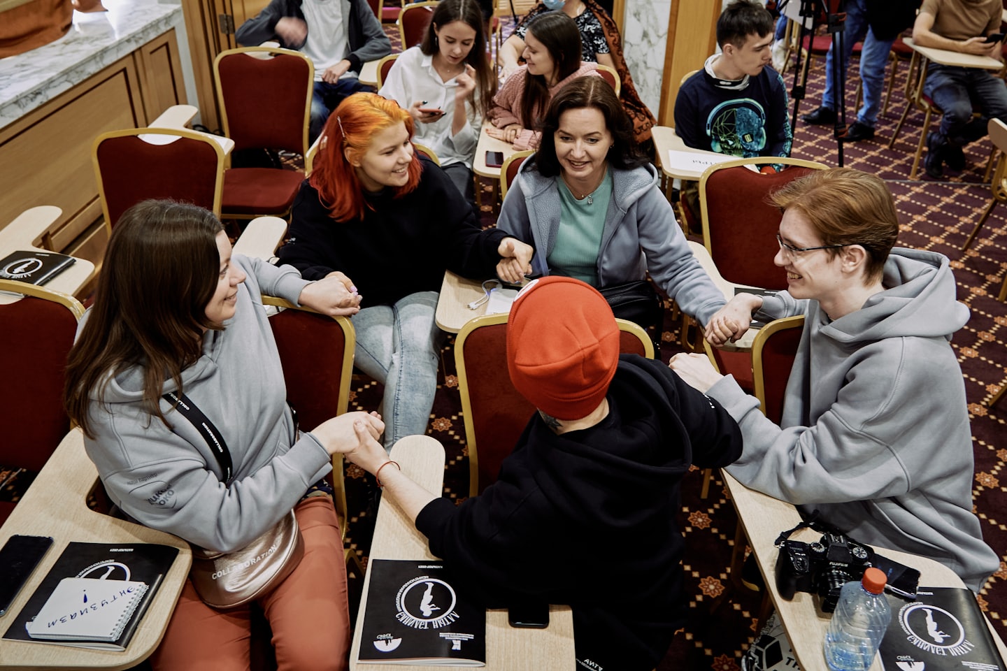 Team holding hands in a circle during a meeting.