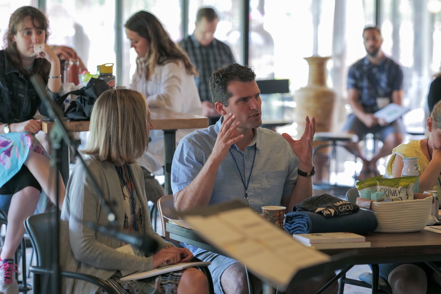 Man gestures while speaking to woman at conference.