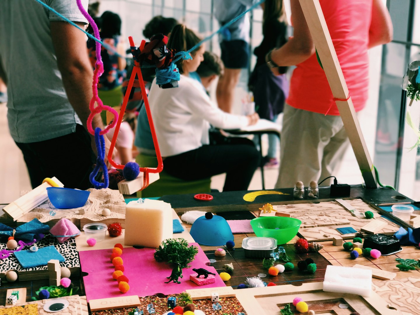 People collaborating on craft projects with colorful materials.