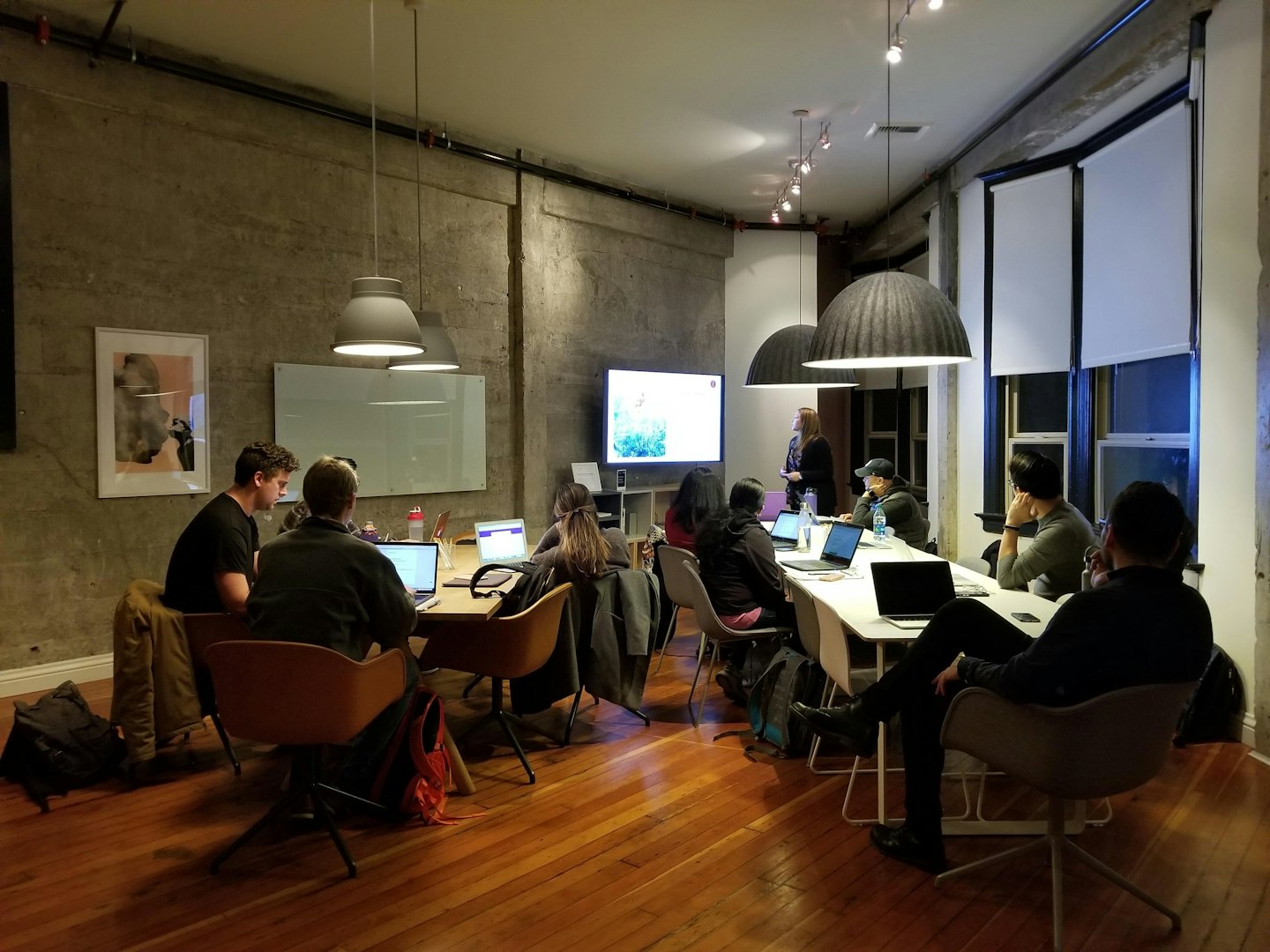 Professionals collaborate around tables in a modern meeting room.