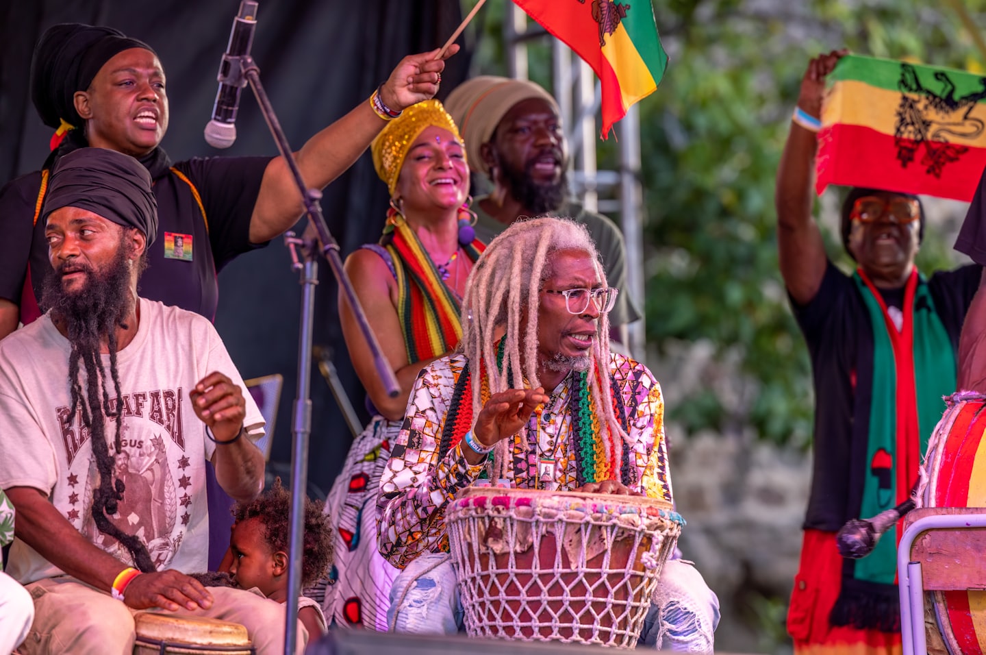 Group of people singing and playing drums at a festival.